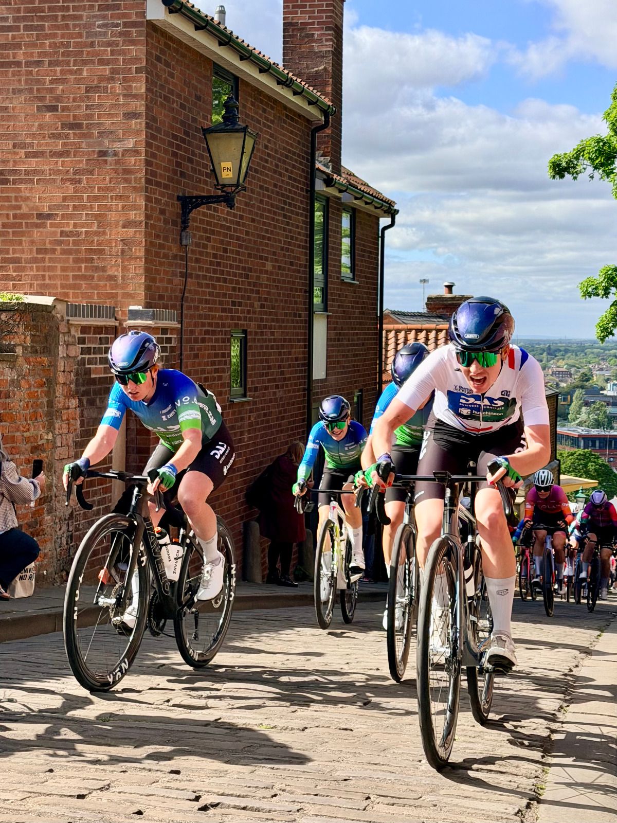 Cyclists climbing a cobbled hill in the Lincoln Grand Prix.